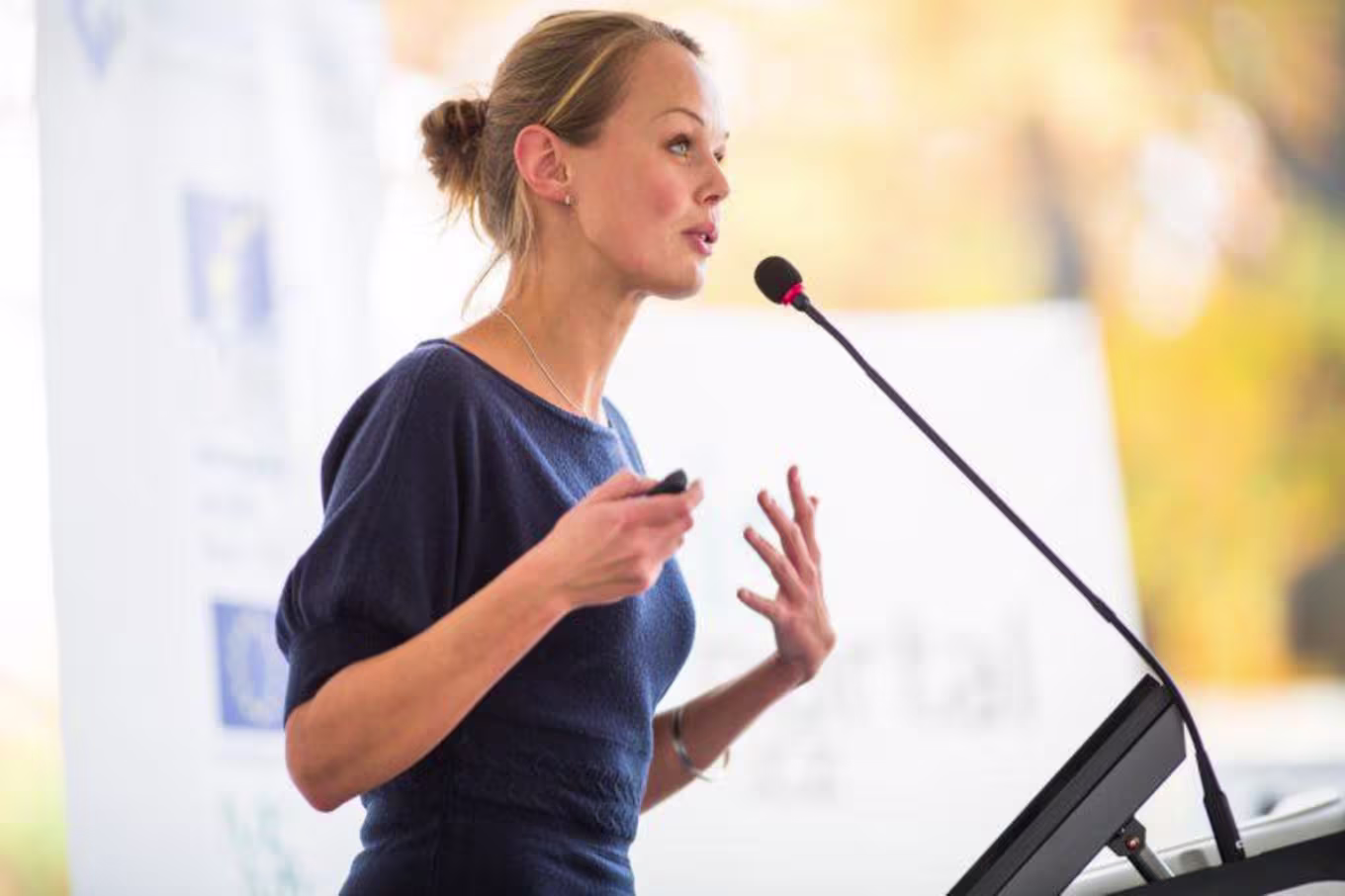 Adult woman speaking into microphone