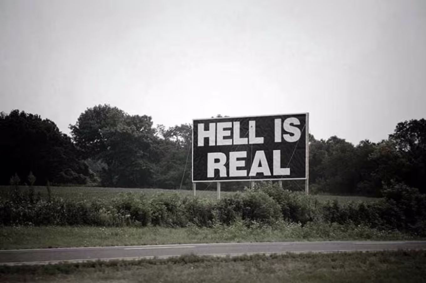 sign that reads "hell is real"
