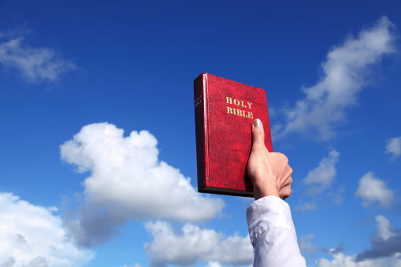 woman holding up Bible, source of Christian worldview