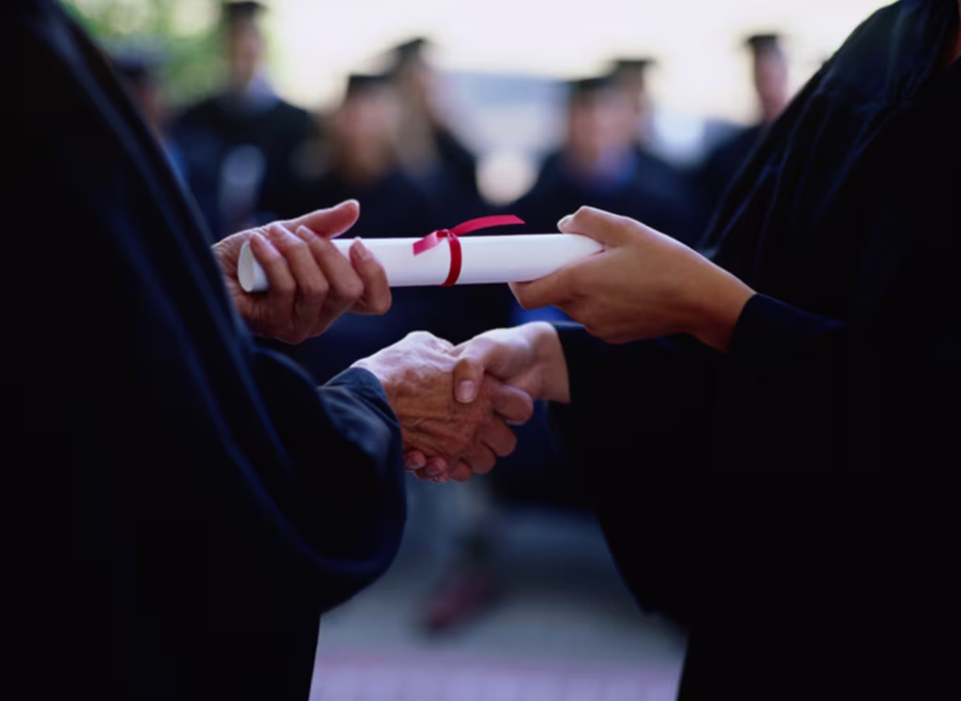 Graduate receiving a diploma, close-up of hands - stock photo