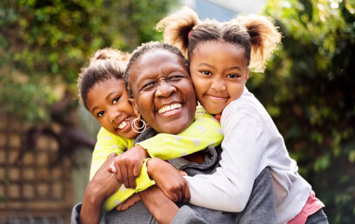 Grandmother and granddaughters showing kindness with group hug