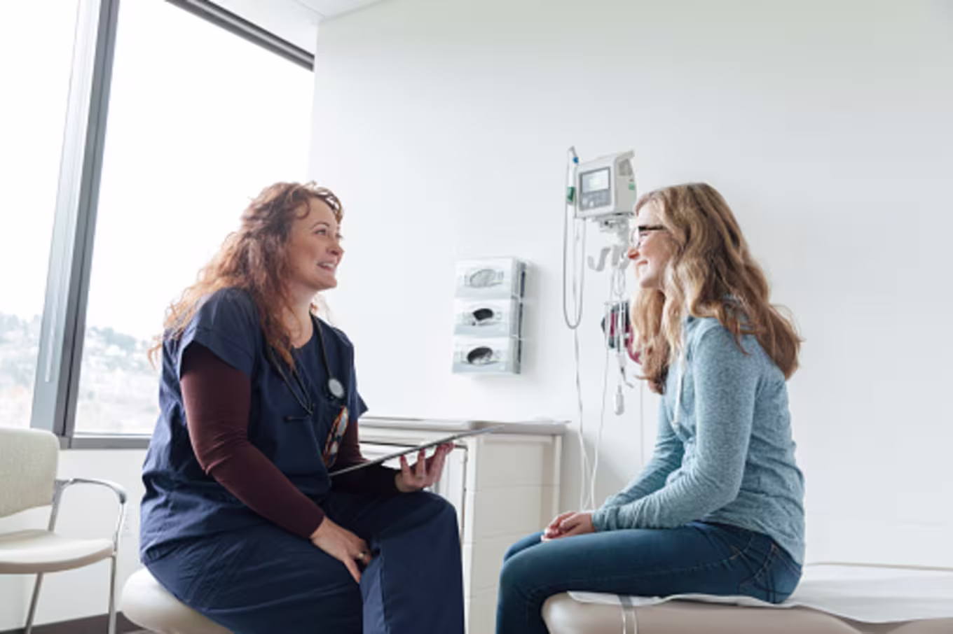 Family nurse practitioner asking teenage patient questions about her health