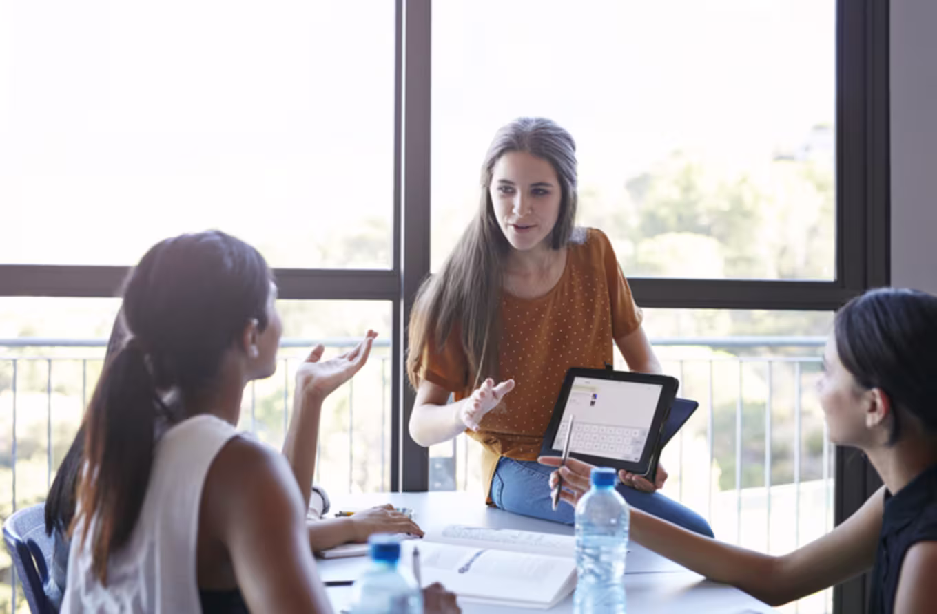Female teacher working with young adult students in classroom