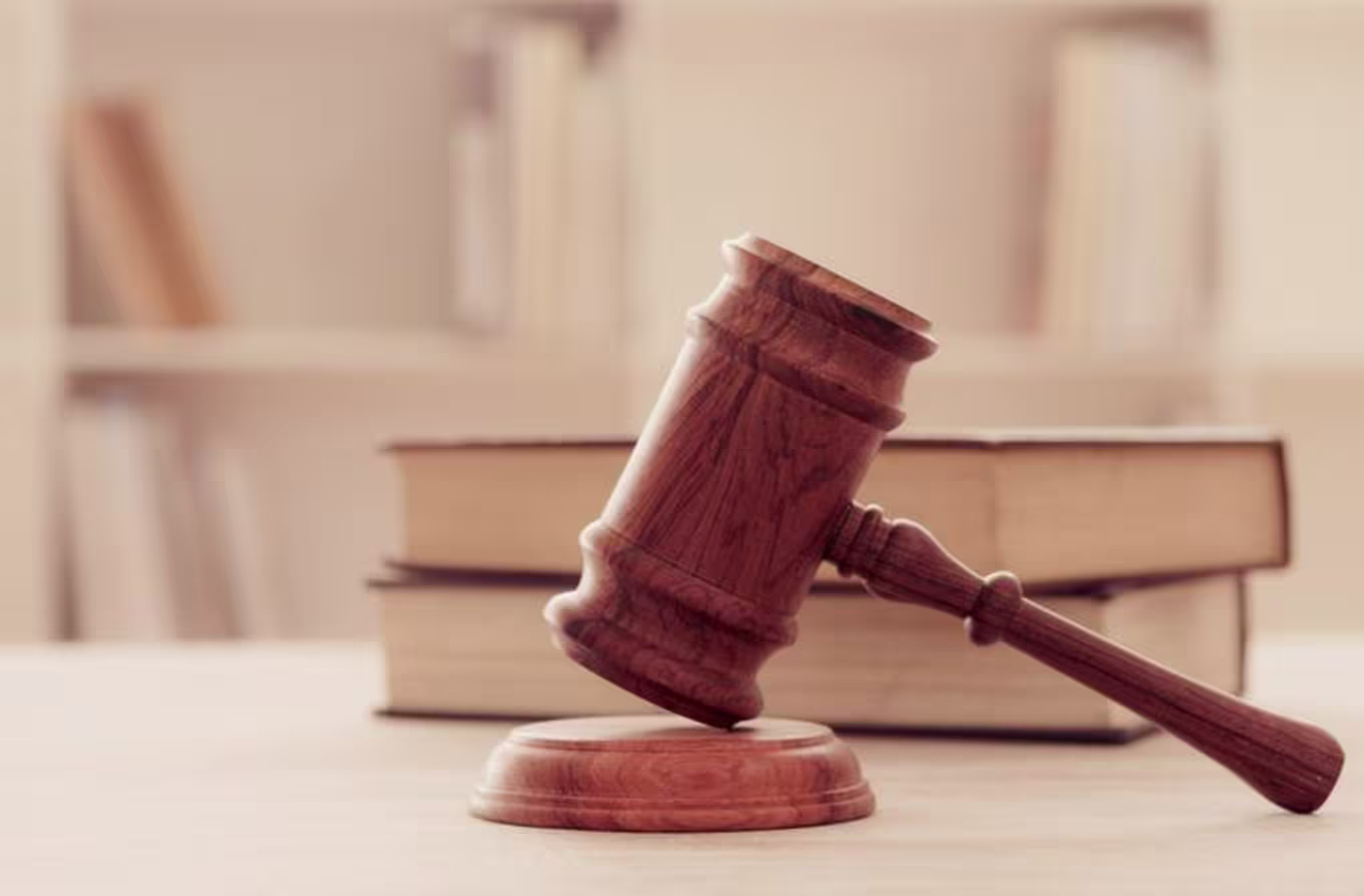 A gavel resting by a stack of books