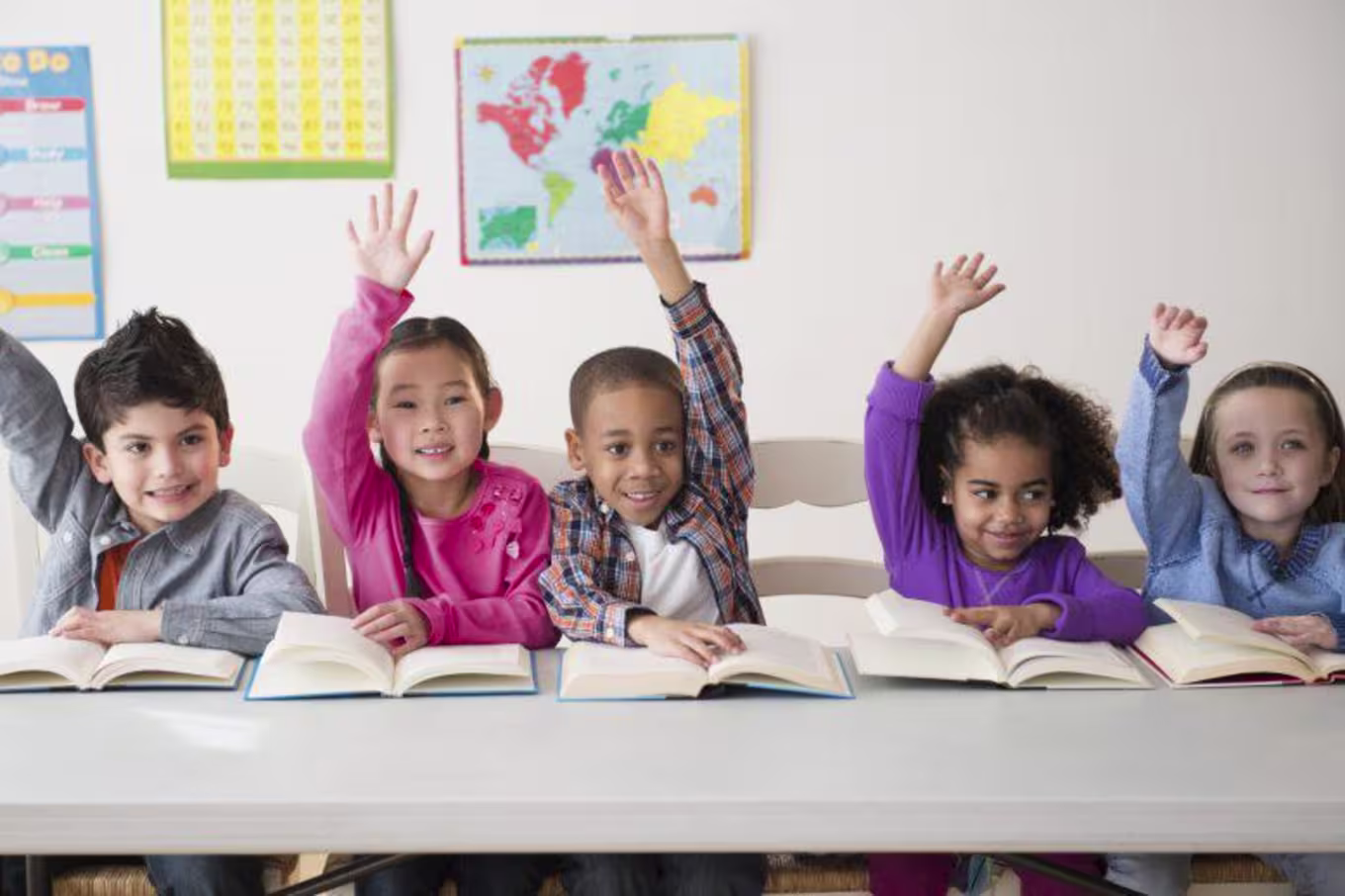 students in a row raising hands