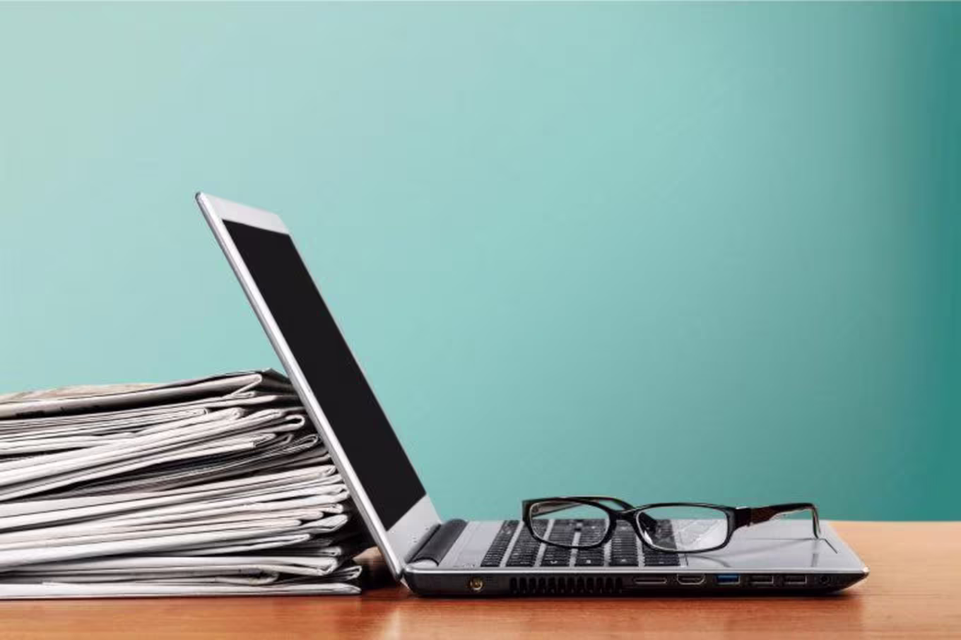 Laptop propped up on a stack of papers