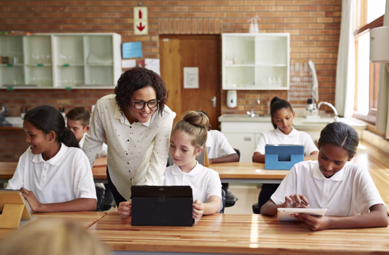female teacher teaching young students in classroom learning environment