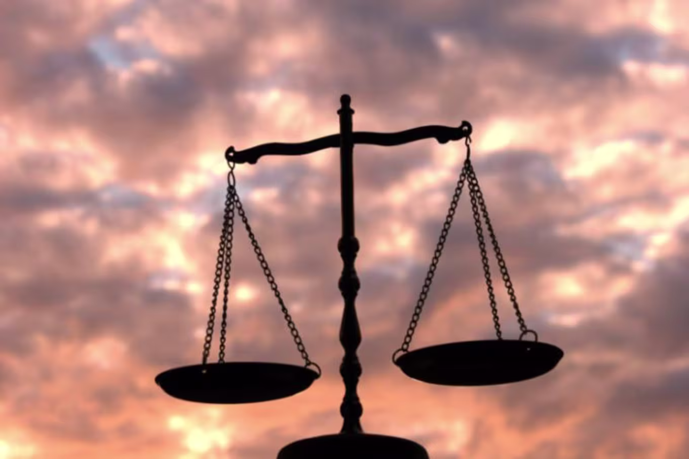 Scales facing a sky during sunset