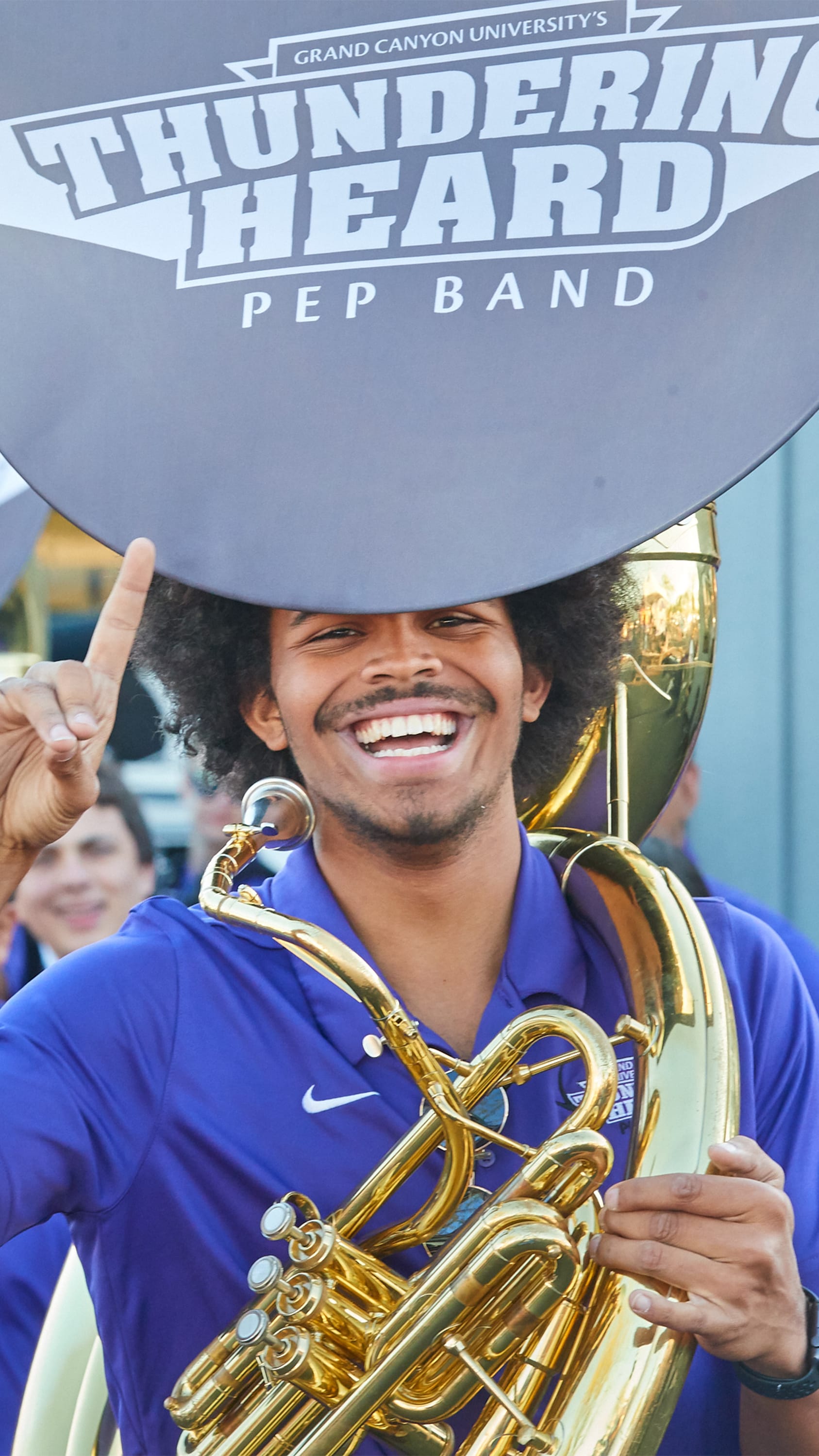 Pep Band member holding instrument at car wash event