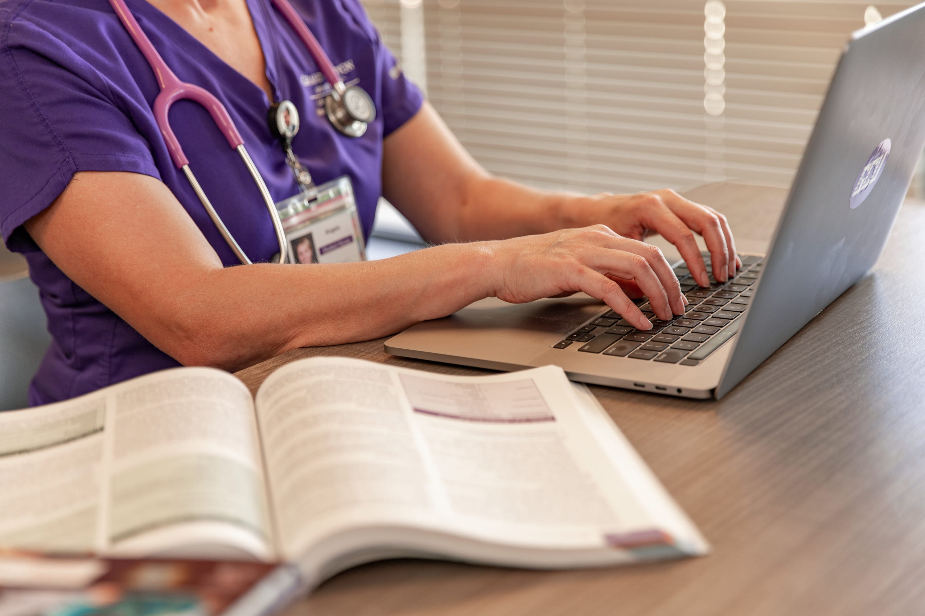 Online nursing student typing on laptop