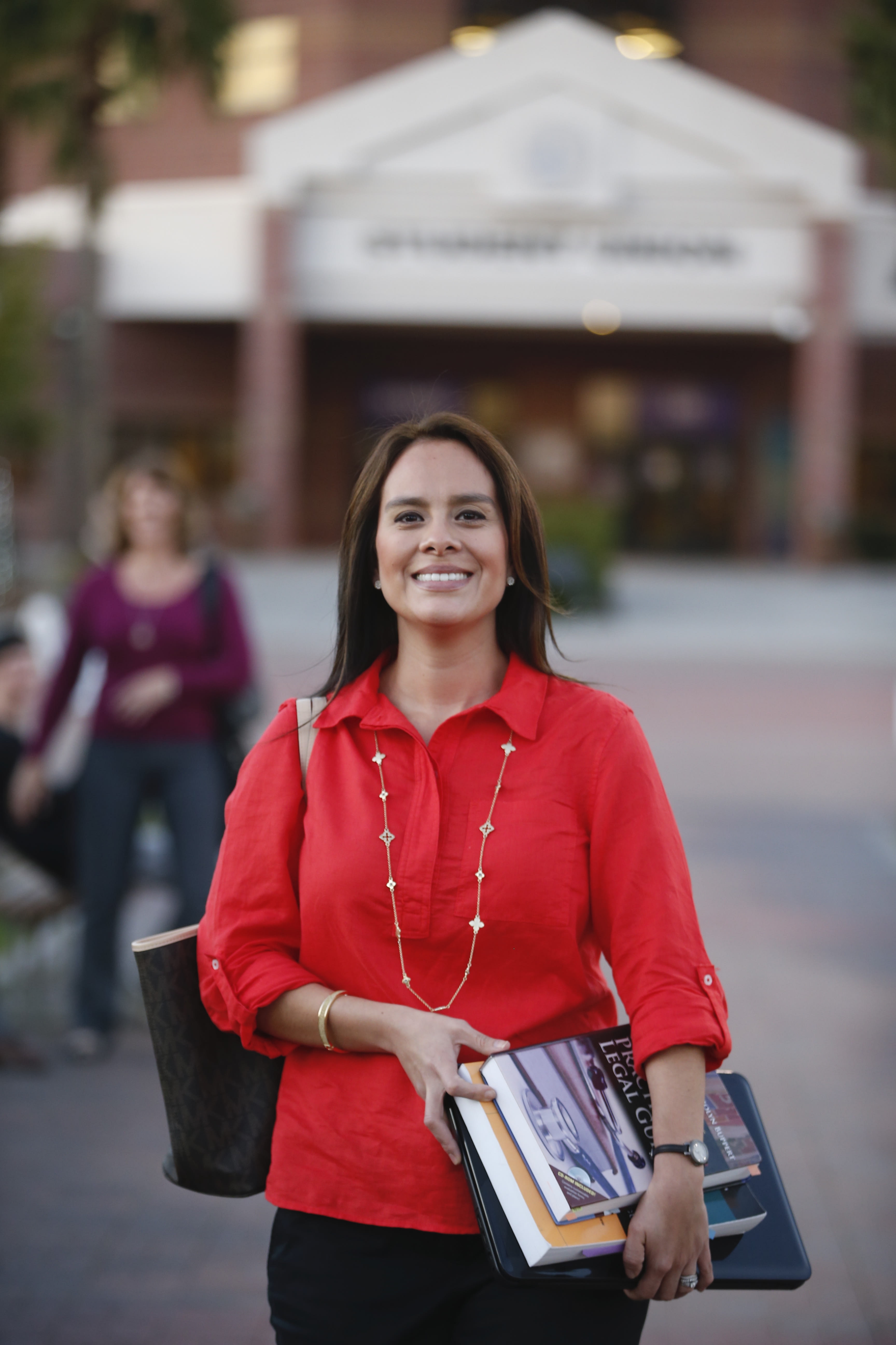 Woman walking on campus with textbooks