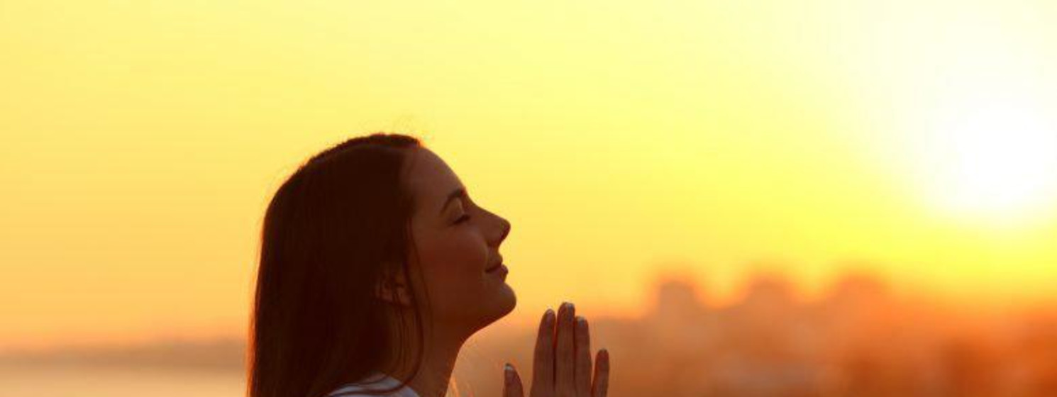 woman praying during sunrise or sunset