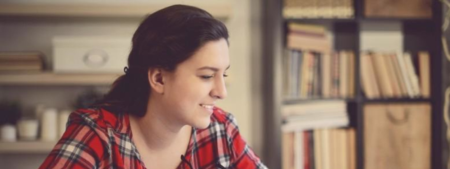 A woman reading behind a stack of books