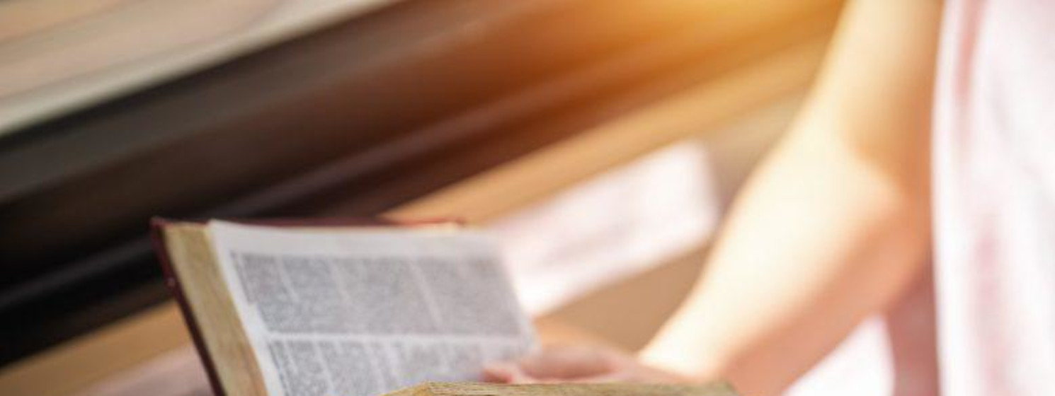 someone holding an open Bible