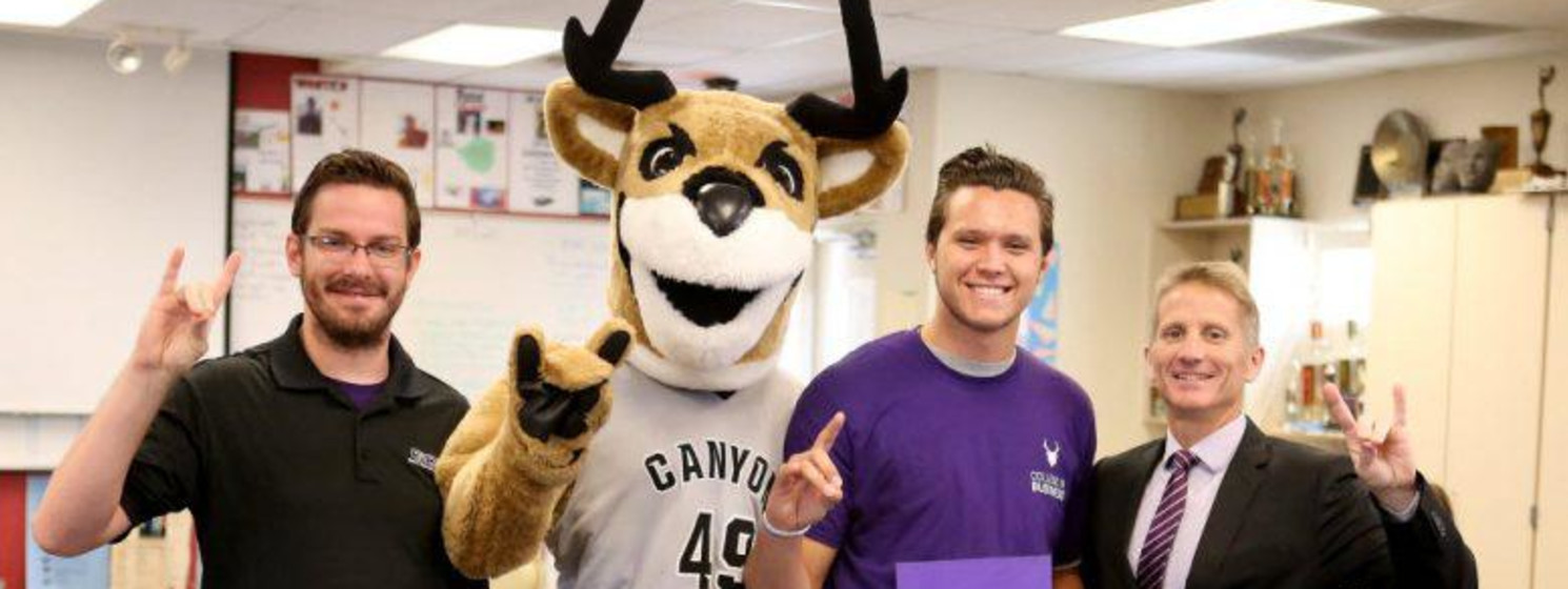 gcu mascot and three people smiling