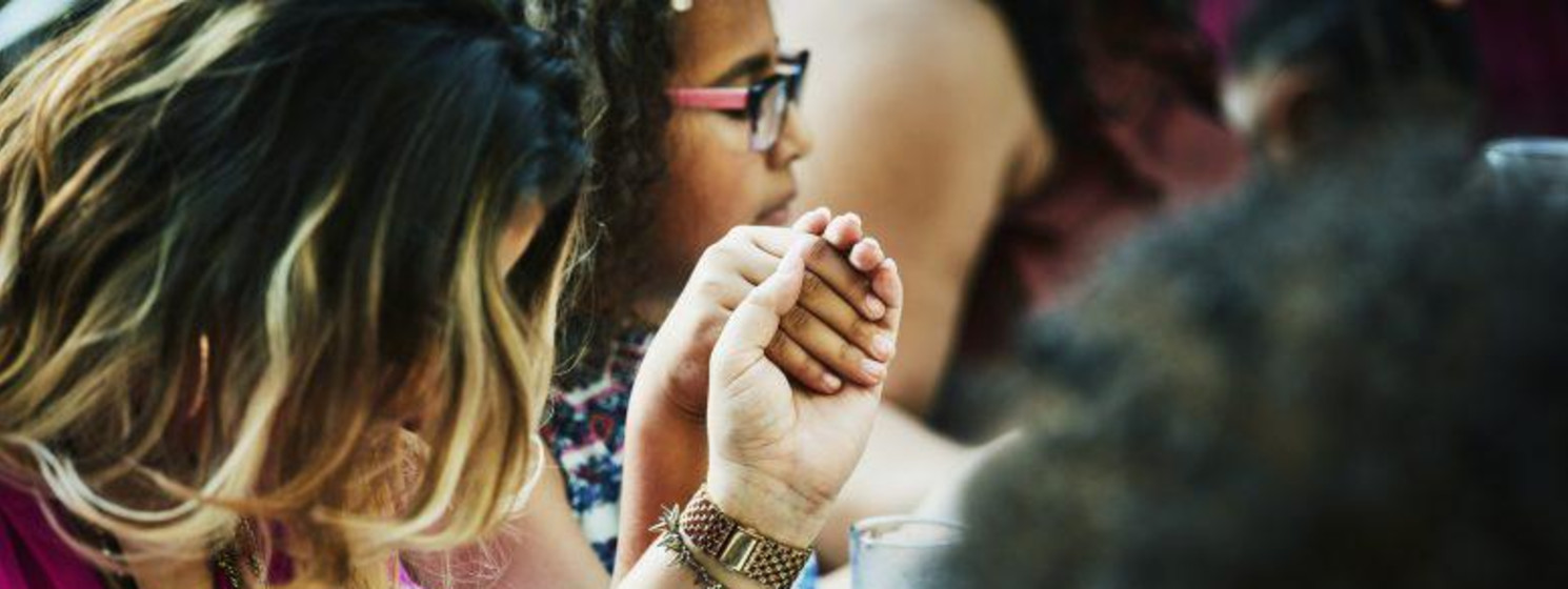 people holding hands at a table