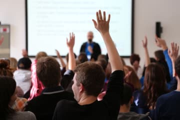 honors students raising their hands in class
