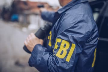 FBI agent in the field holding binoculars