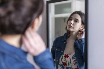 young woman looking in the mirror