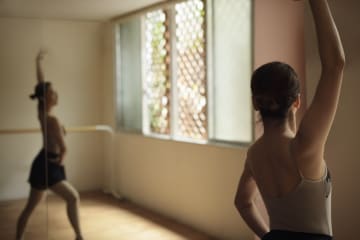 Ballerina exercising in studio - stock photo
