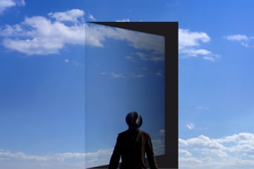 Man stands in front of the opened door in the sky. - stock photo