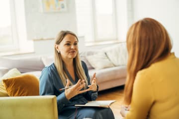 Two women talking and sitting in chairs