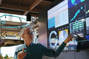 Man pointing and explaining analytics displayed on screen