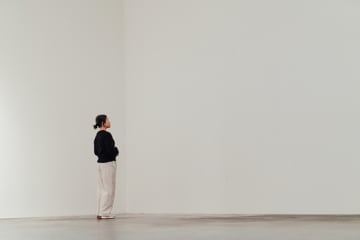 A simple white room with a Woman wandering.