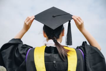Student wearing graduation cap and gown on commencement day 