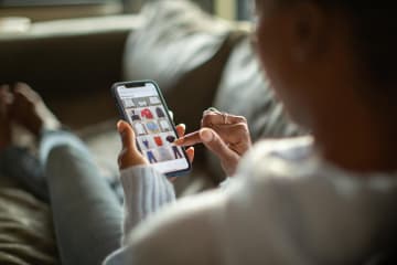 Woman scrolling and looking at clothes on phone