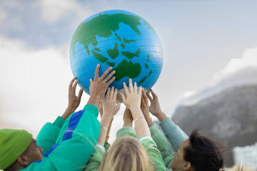 Group of teenagers holding up the world - stock photo