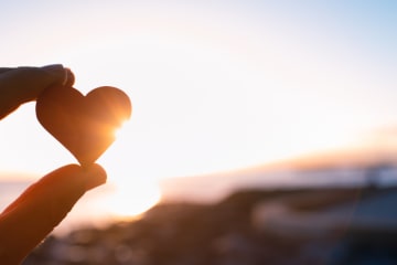 Hand holding here in the sunset. I love nature concept - stock photo