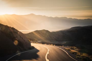Highway at sunrise, going into Death Valley National Park - stock photo