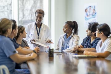 Mental health professional leads boardroom discussion on behavioral healthcare.
