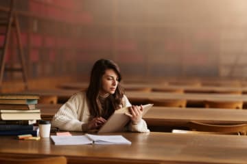 student reading in a library by herself