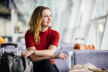 woman waiting patiently in airport smiling