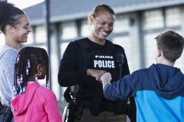 Police officer bumps fists with an 11-year-old.