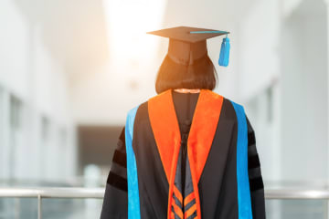 PhD student in cap and gown for graduation