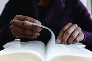 Woman Reading Bible Turns Page - stock photo