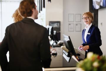 Business couple arriving at hotel reception desk
