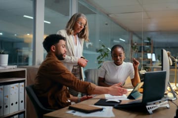 3 writers working on a project at a desk