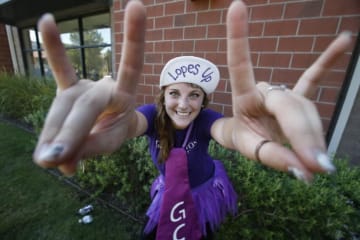 student wearing purple holding lopes up