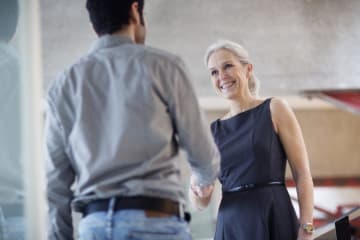 Man and woman greeting each other during an interview