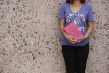 A student in a GCU shirt holding the Bible