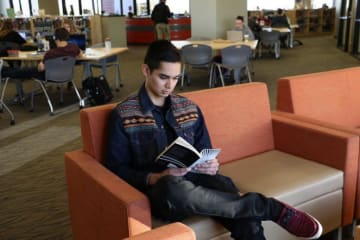 A GCU student reading in the library