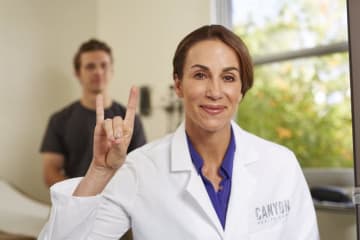 GCU nurse holding her hand in a lopes up