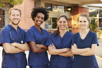 Four nurses standing with arms crossed