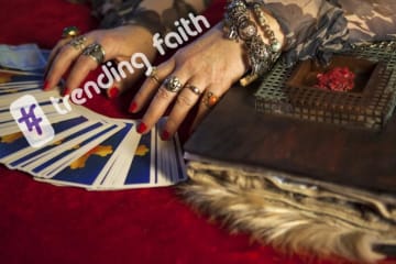 The trending faith logo over a pair of psychic's hands