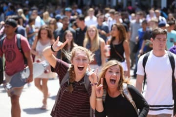 crowd of students, two holding lopes up
