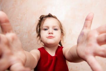 Young child reaching her arms out